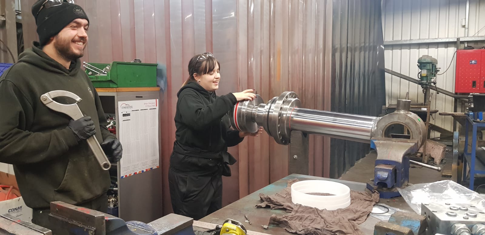Two ACE engineers working on a large hydraulic ram