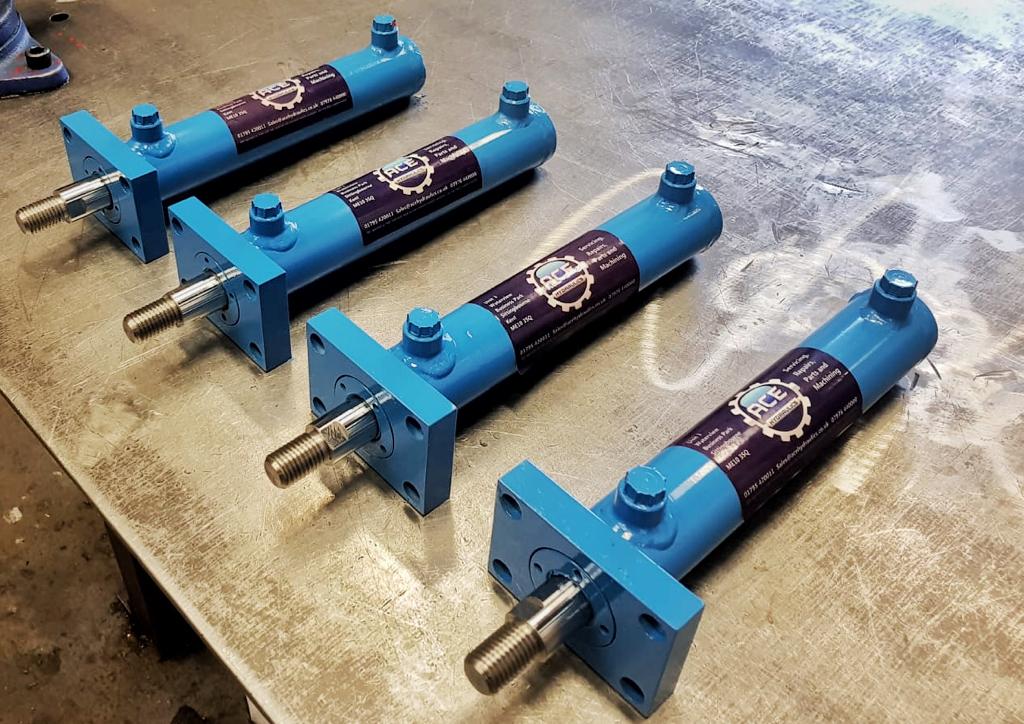 Blue hydraulic cylinders with ACE Hydraulics branding